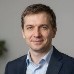 Портрет уверенного российского бизнесмена с дружелюбным взглядом на размытом нейтральном фоне в студии